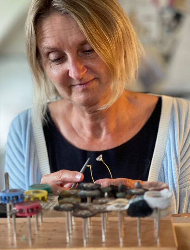 Jewellery artist Rikke Lunnemann carefully crafts pieces from various materials, showcasing her intricate work.