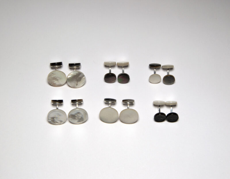 Collection of six pairs of cufflinks in various designs, arranged on a white background.