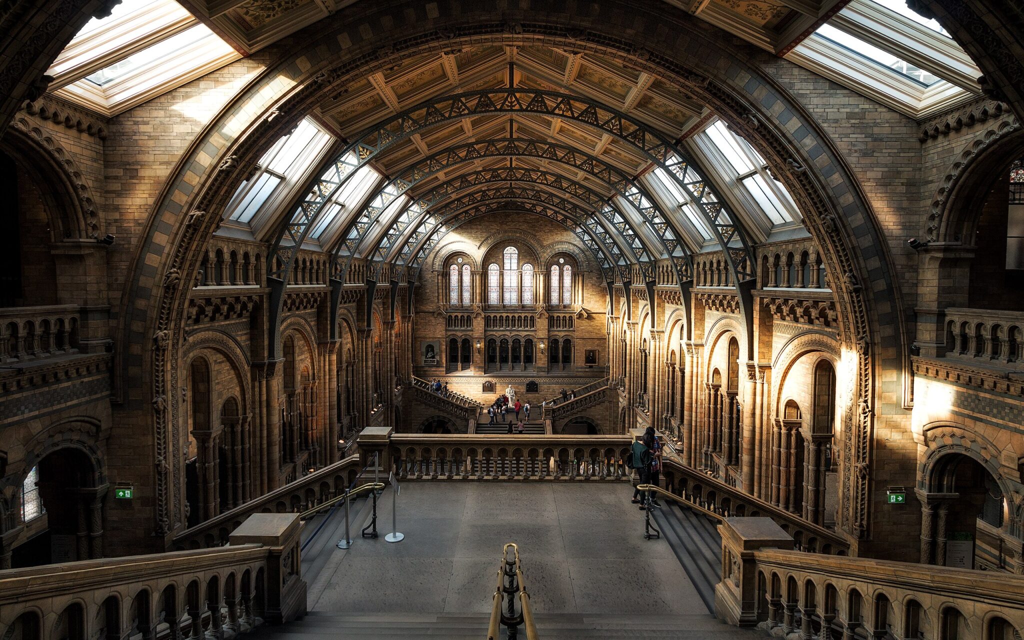 Interior view of the Natural History Museum in London, showcasing grand architecture and natural light streaming through w...