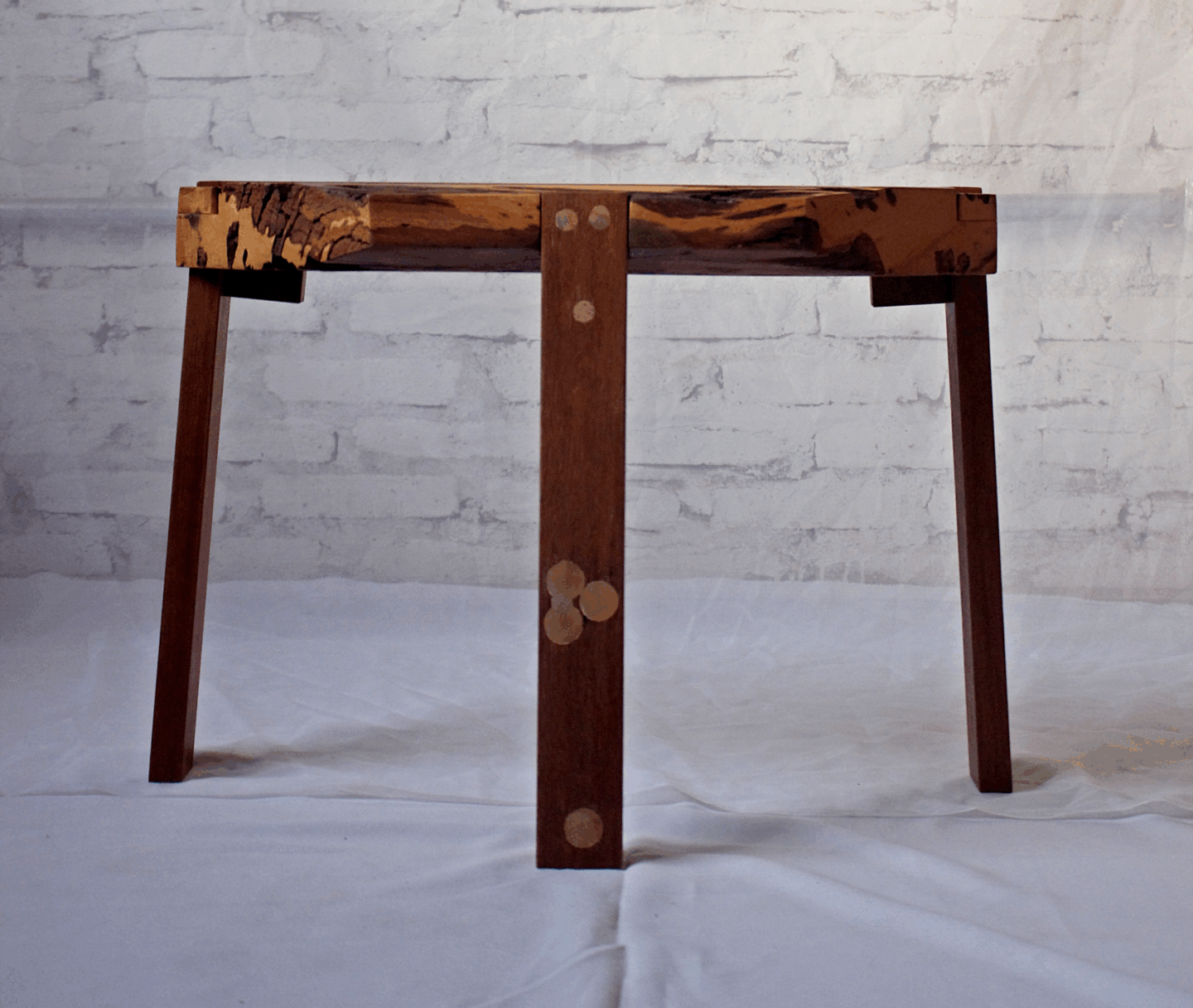 Wooden chair with a unique spalted top and simple wooden legs, set against a light textured background.