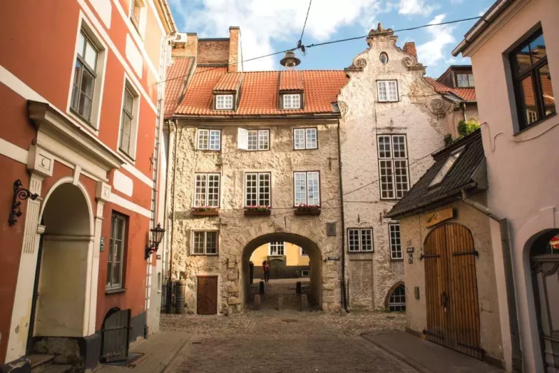 Old brick buildings and archways in Riga's old town, showcasing historical architecture and cobblestone streets.