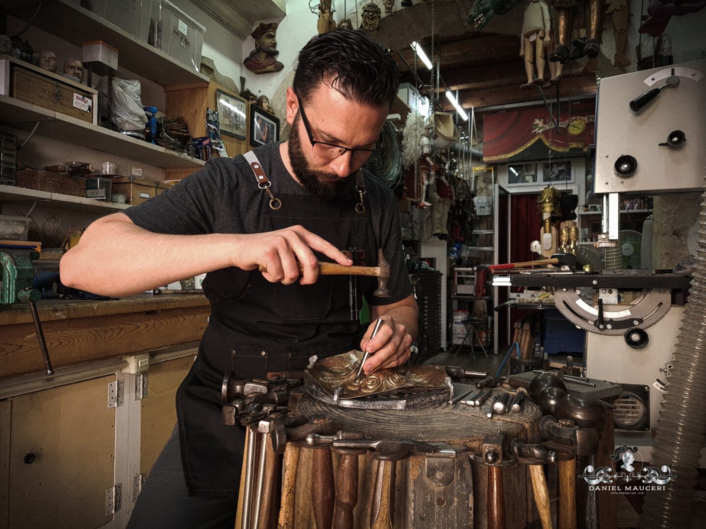 Daniel Mauceri in his studio, using the repoussé technique to sculpt intricate metal details.