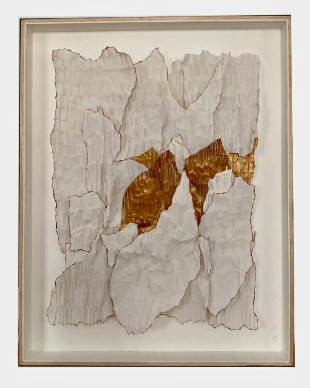 Abstract artwork featuring layered white and gold textured paper, framed elegantly.
