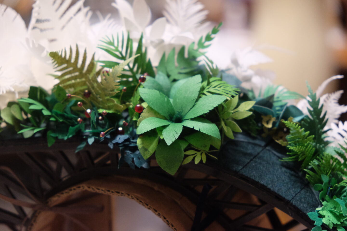 Colorful paper plants and ferns arranged on a decorative arch, showcasing Marie Grimaud's award-winning design.