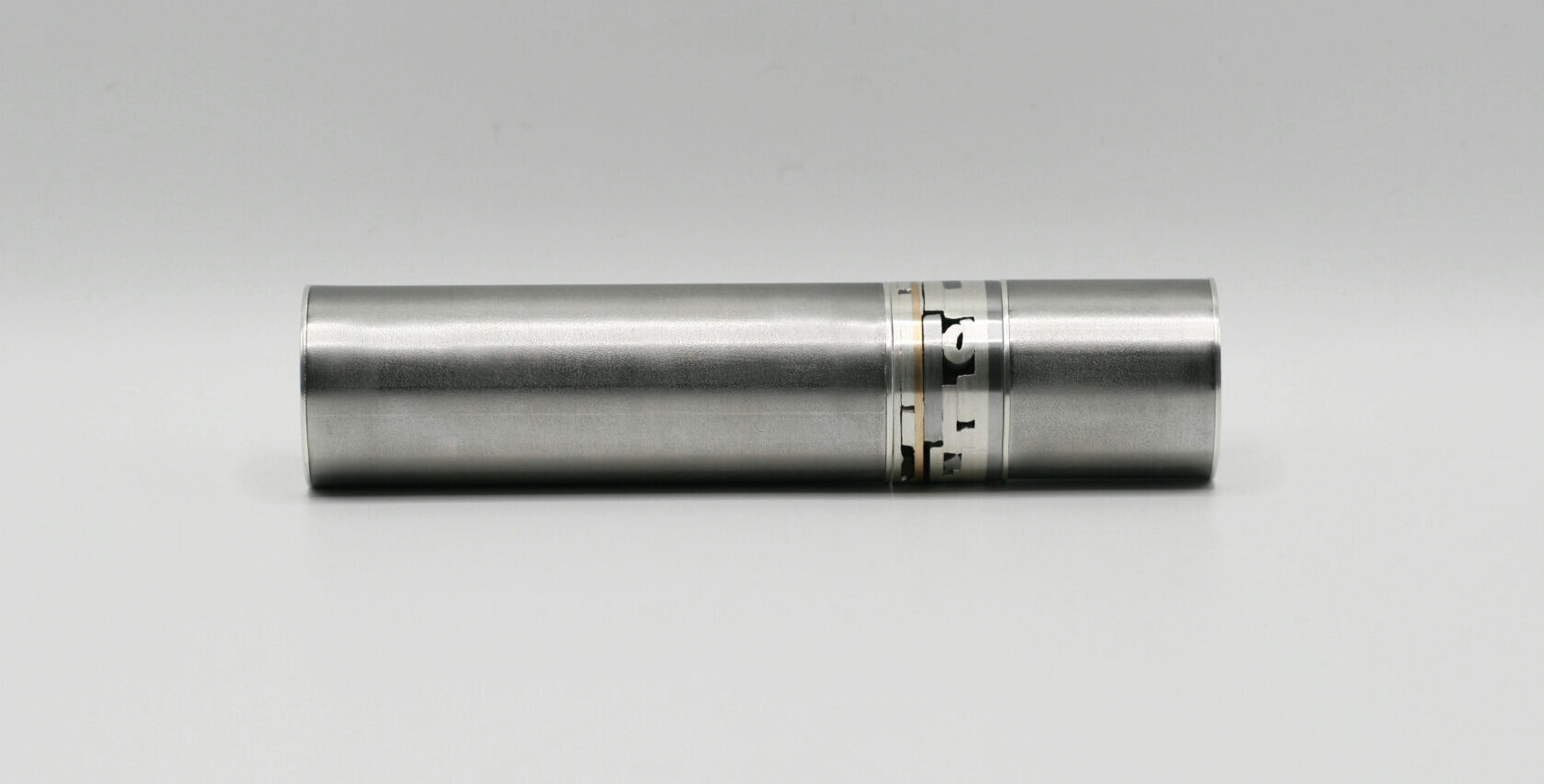 Metallic cylindrical object with engraved markings, placed on a plain white background.