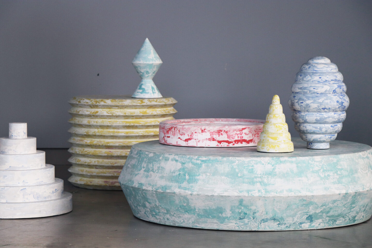 Colorful, intricate sculptural pieces designed for the 2018 Reform Design Biennale, displayed on a gray background.