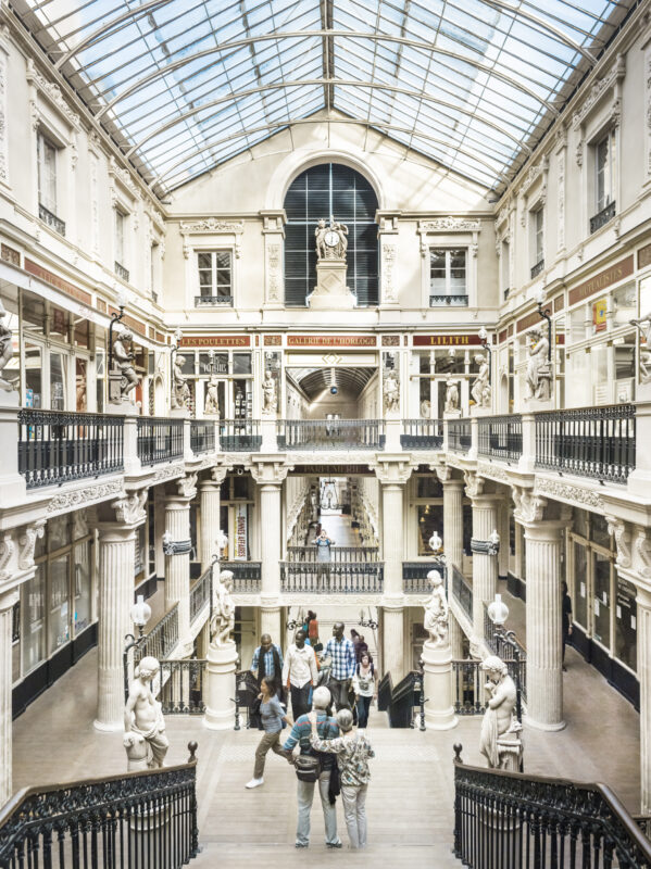 Passage Pommeraye in Nantes, showcasing elegant architecture, sculptures, and visitors exploring the space.