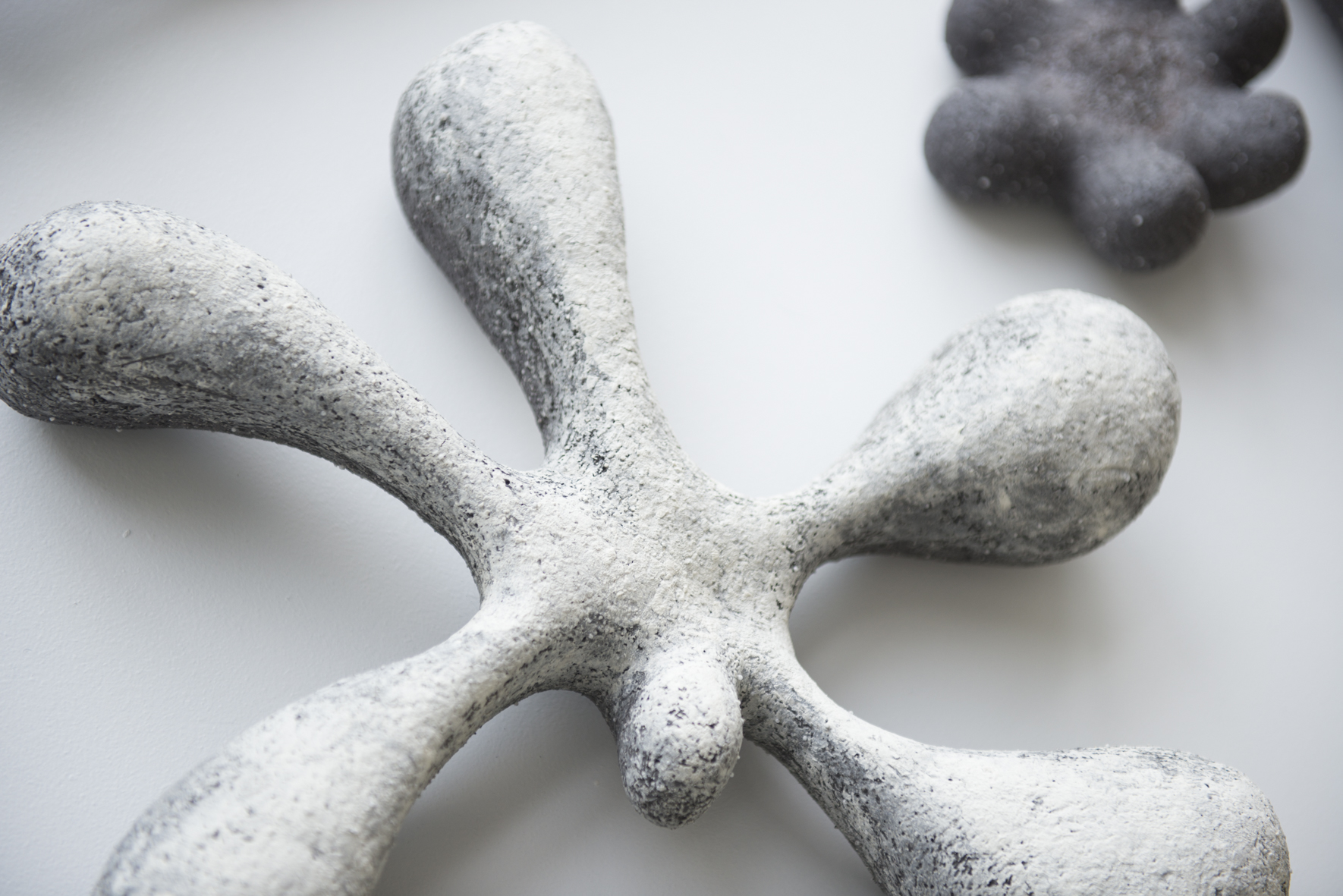Ceramic sculpture by Kristín Garðarsdóttir, featuring organic shapes in gray and white textures.
