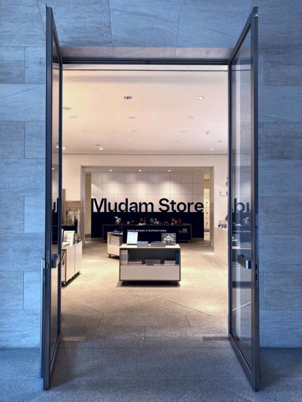 Entrance to Mudam Store showcasing modern art items, with sleek displays and minimalist design.