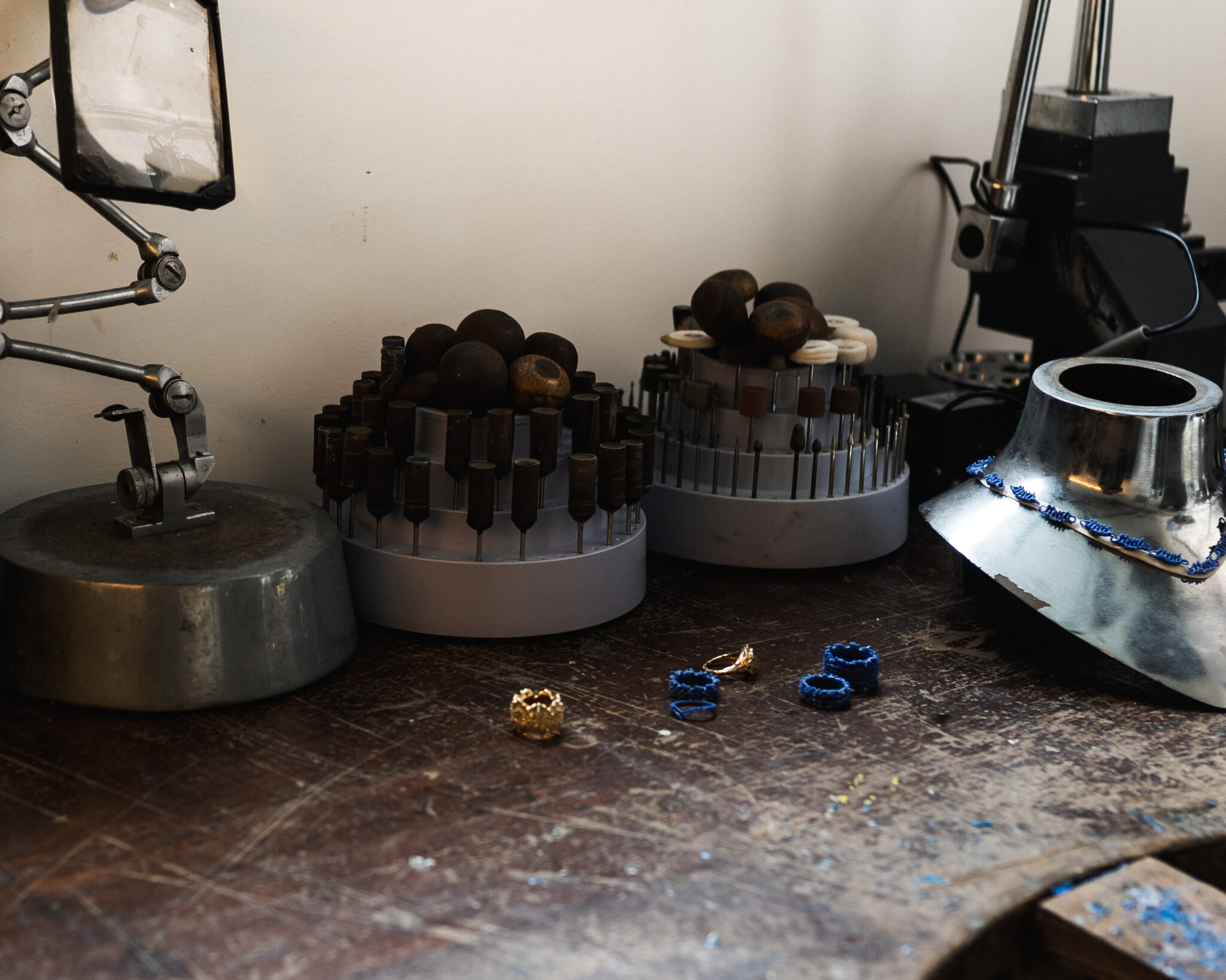 Tools and materials on a workbench in Cameron's studio, including molds and jewelry pieces.