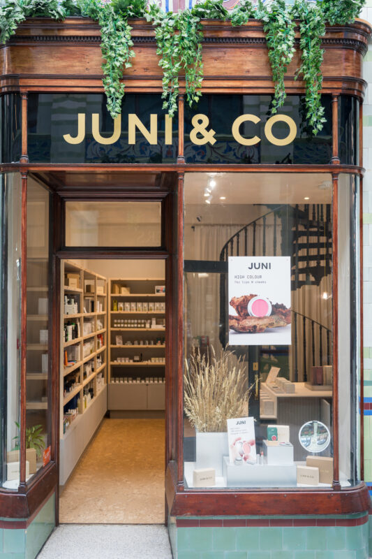 Storefront of JUNI & CO with large signage, showcasing products and a welcoming interior.
