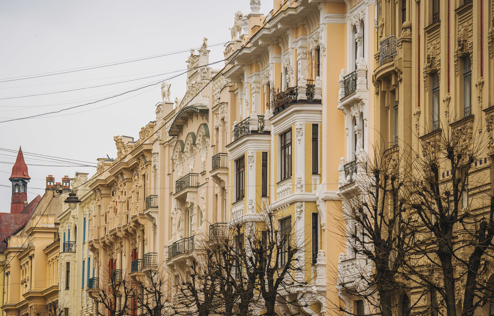Art Nouveau facades in Riga, showcasing intricate architectural details and bare trees in the foreground.