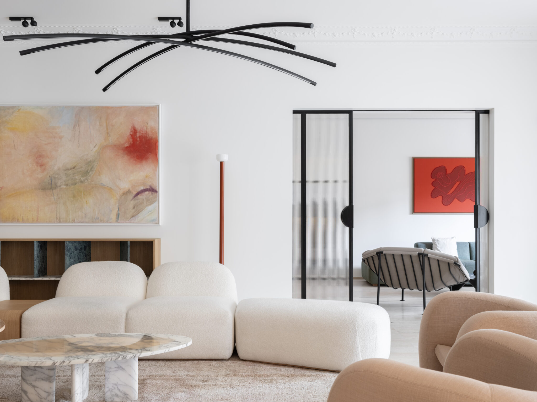 Modern residential apartment interior featuring sculptural furniture, abstract art, and a minimalist design aesthetic.