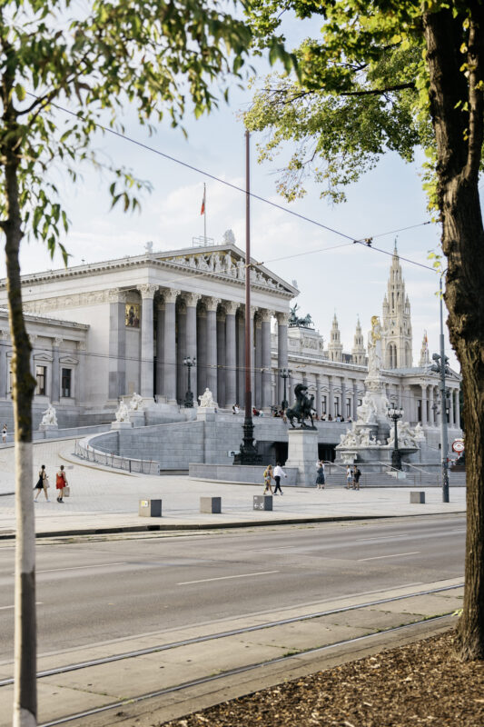 Parliament building on Ringstraße in Vienna, featuring classical architecture and summer daylight.