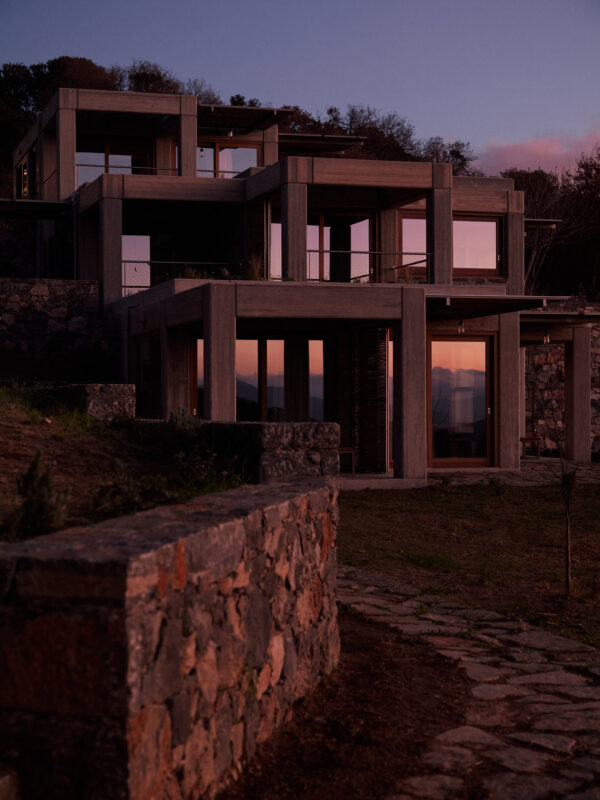 Studios at sunset, illuminated in purple hues, with stone pathways and modern architecture.