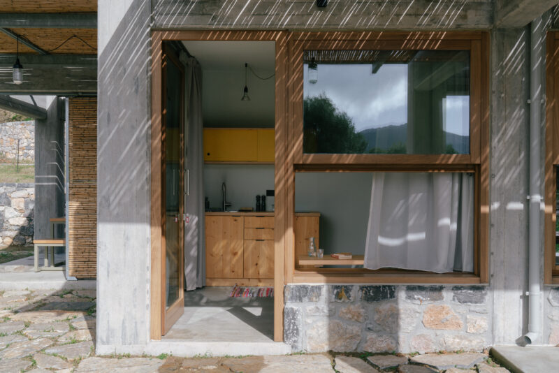 Modern architectural design featuring large windows with wooden frames, showcasing a cozy interior with yellow accents and...