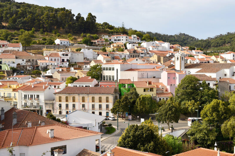 View of Monchique, Portugal, showcasing colorful buildings and lush hills in the background.