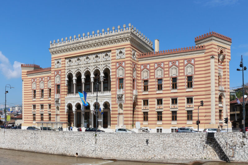 Sarajevo City Hall, a historic building with a striped facade, set against a blue sky.