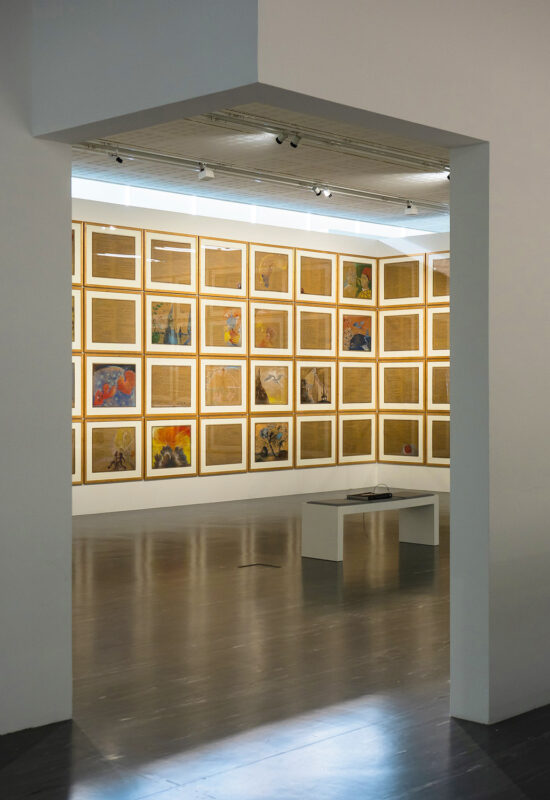 Gallery view featuring a wall of framed artworks and a central display table, uploaded to Hotel Motto.