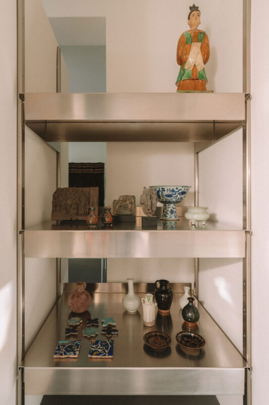 Shelves displaying various decorative items, including ceramics, figurines, and small sculptures.