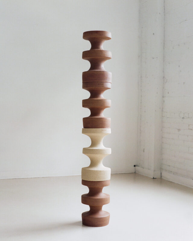 Stacked wooden side tables in varying shapes and colors, showcasing a modern design aesthetic.