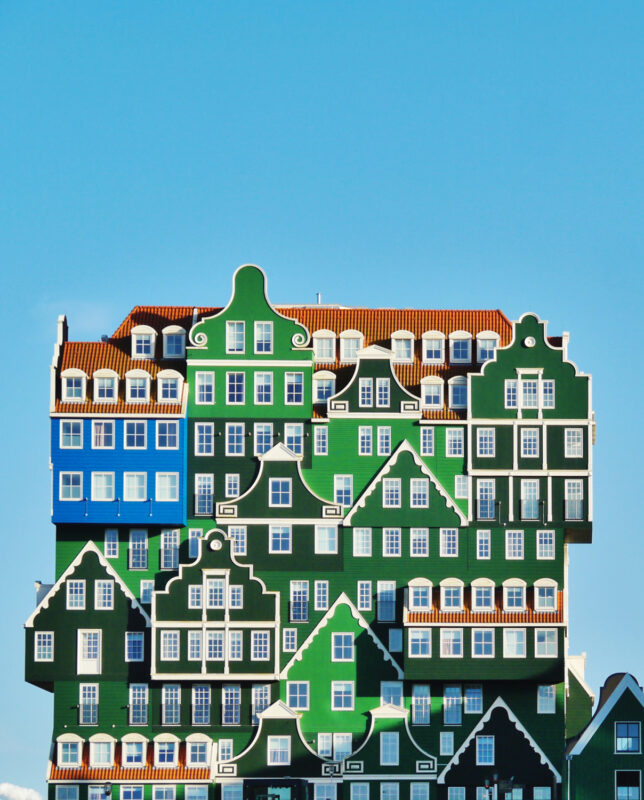 Colorful, stacked building resembling traditional Dutch houses against a clear blue sky.