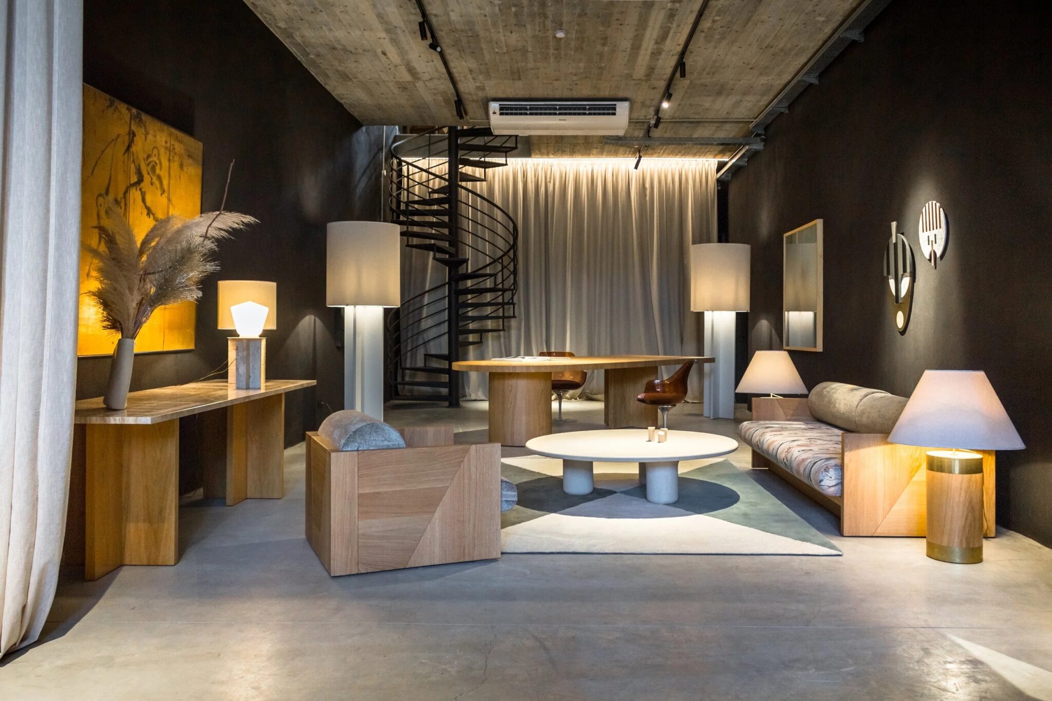 Modern interior design featuring a spiral staircase, wooden furniture, and stylish lighting in a dark room.