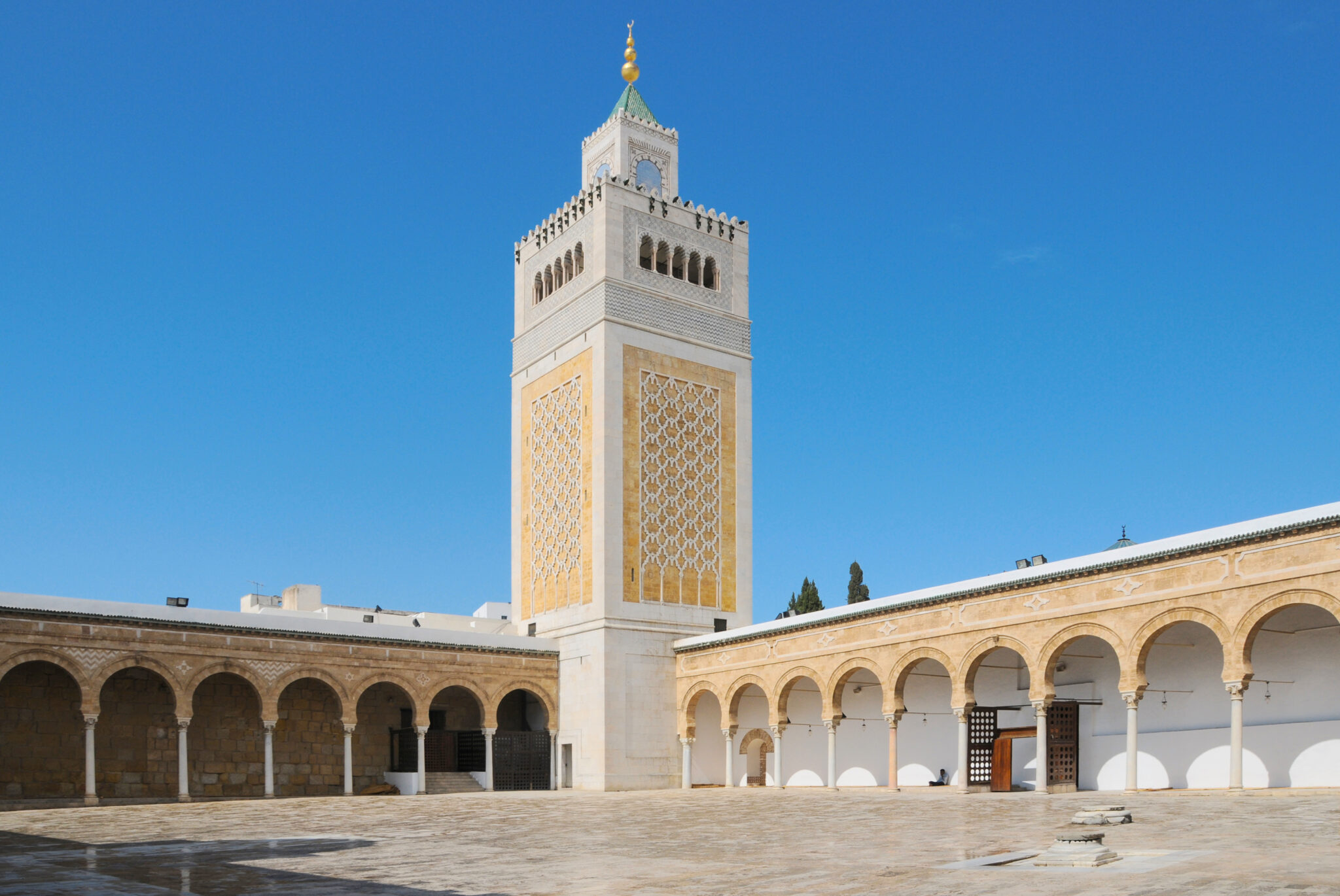 Minaret of the Zitouna Mosque in Tunis, featuring intricate patterns and a clear blue sky.