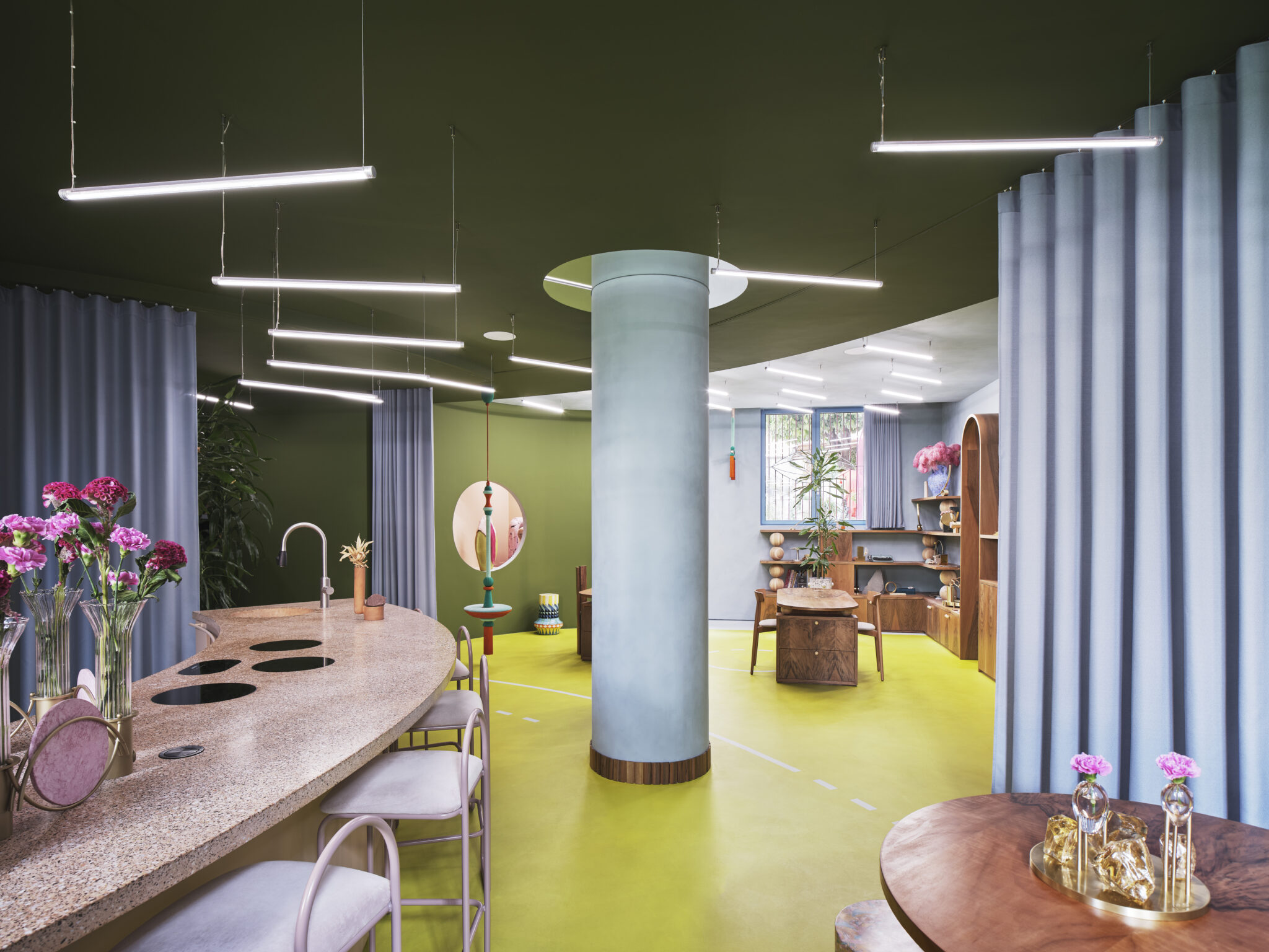 Colorful interior of a modern space featuring a curved bar, plants, and unique furniture, with bright lighting and decorat...