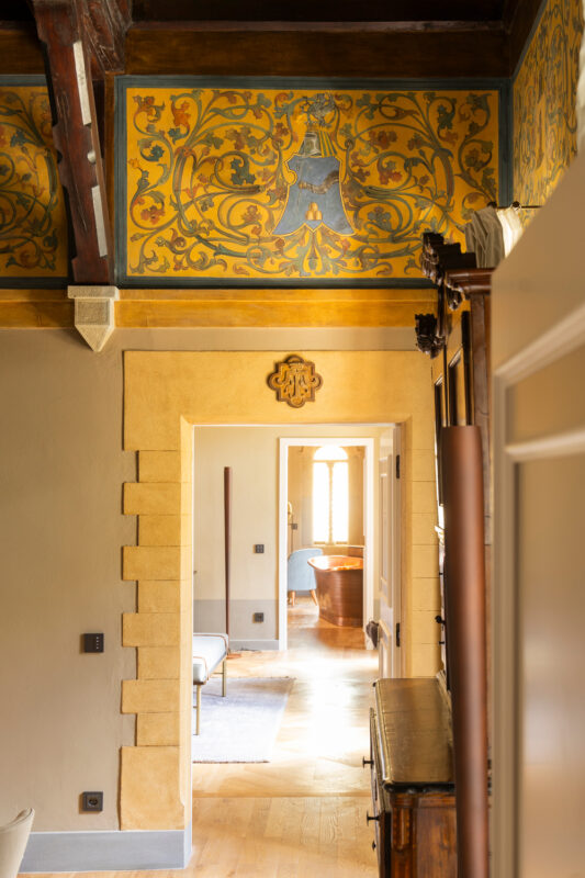 Elegant interior of Rossi Scotti Apartment at Borgo Dei Conti Resort, featuring ornate wall decorations and warm lighting.