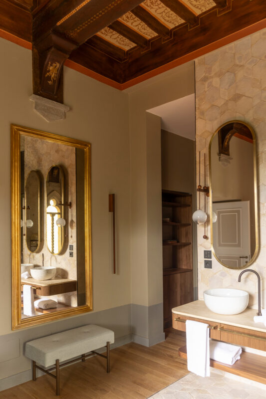 Elegant bathroom in Borgo Dei Conti Resort featuring a large mirror, modern sink, and wooden accents.