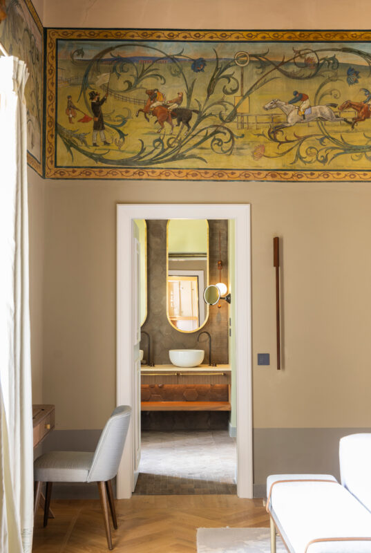 Detail of the Suite della Contessa at Borgo Dei Conti Resort, featuring ornate wall murals and a view into the bathroom.
