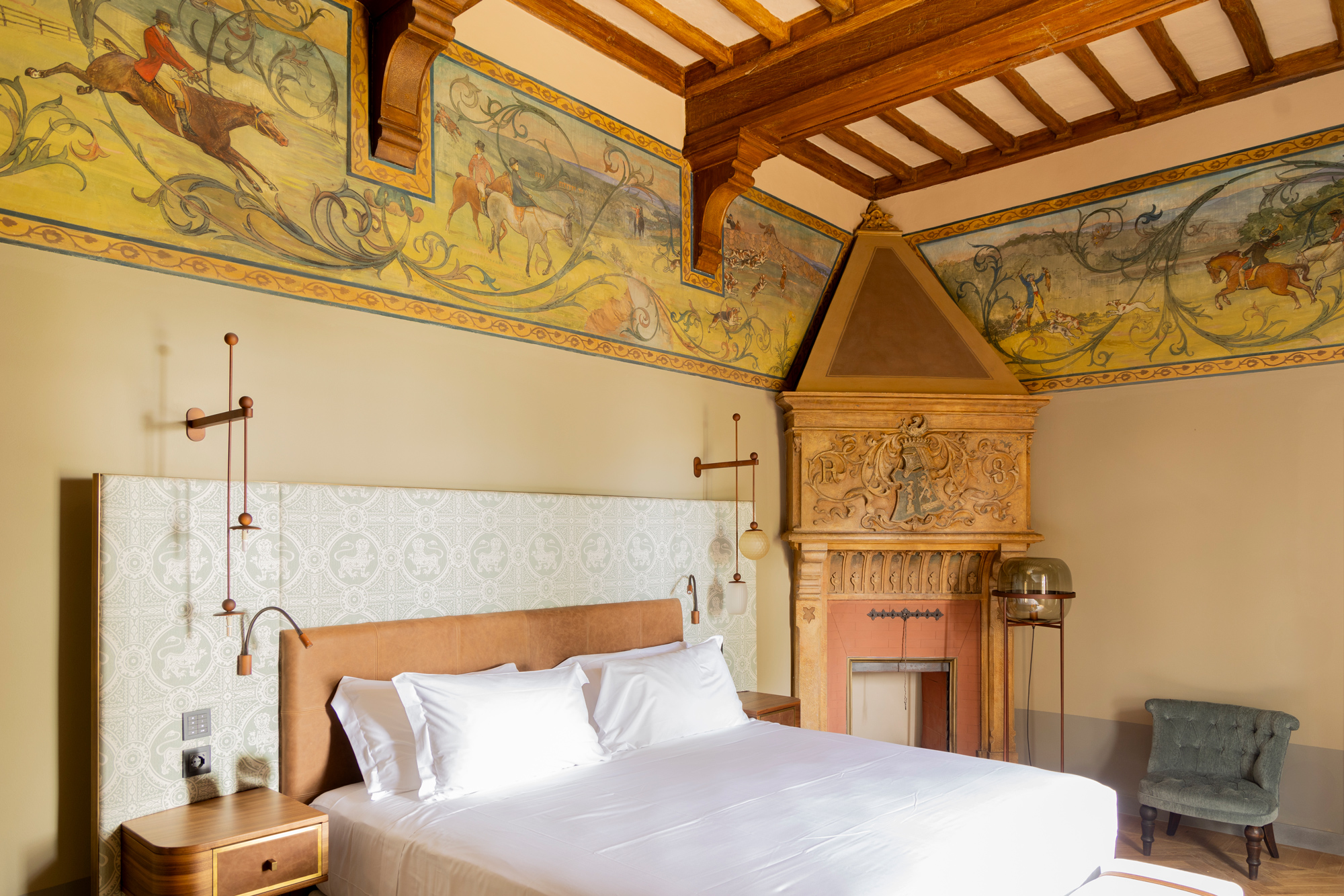 Elegant bedroom in Borgo Dei Conti Resort featuring a decorative ceiling, frescoed walls, and a vintage fireplace.