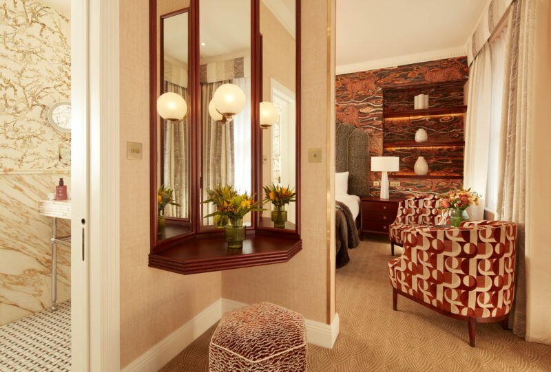 Elegant three-bedroom suite featuring a stylish seating area, decorative wall, and a marble bathroom.