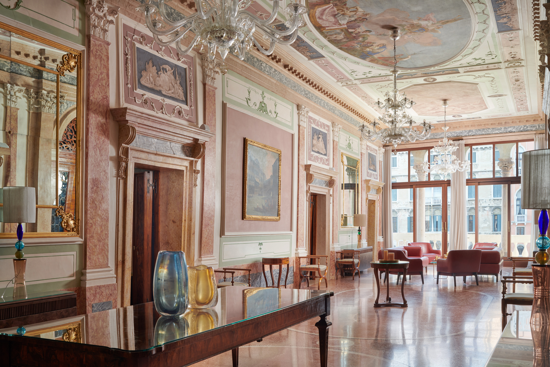 Elegant living room in Palazzo Garzoni featuring ornate ceilings, chandeliers, and stylish furniture.