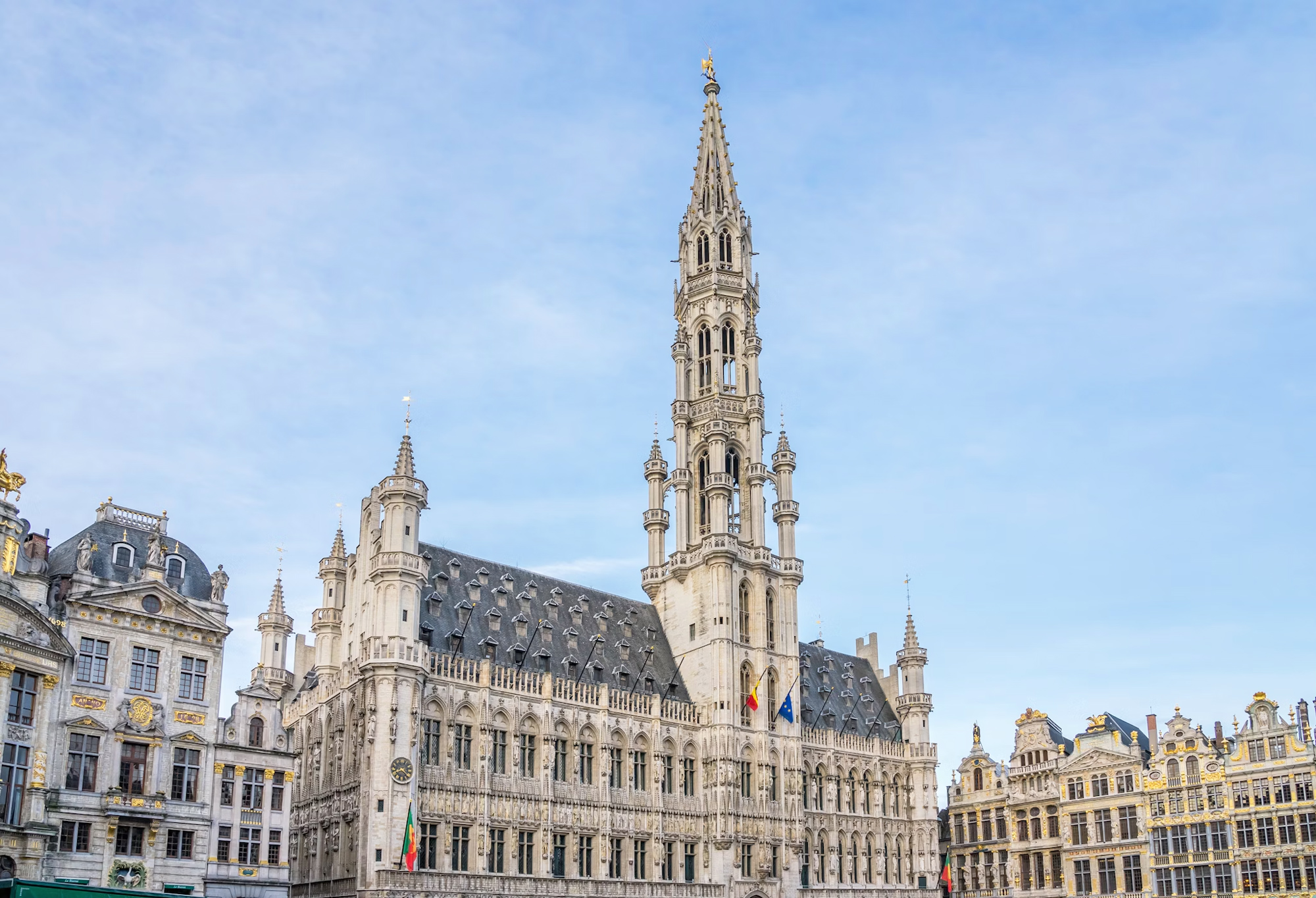 Brussels Town Hall with ornate architecture and a tall spire against a clear blue sky.