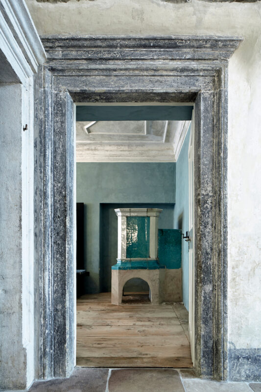 Interior view through a doorway showcasing a room with blue walls and a decorative fireplace.