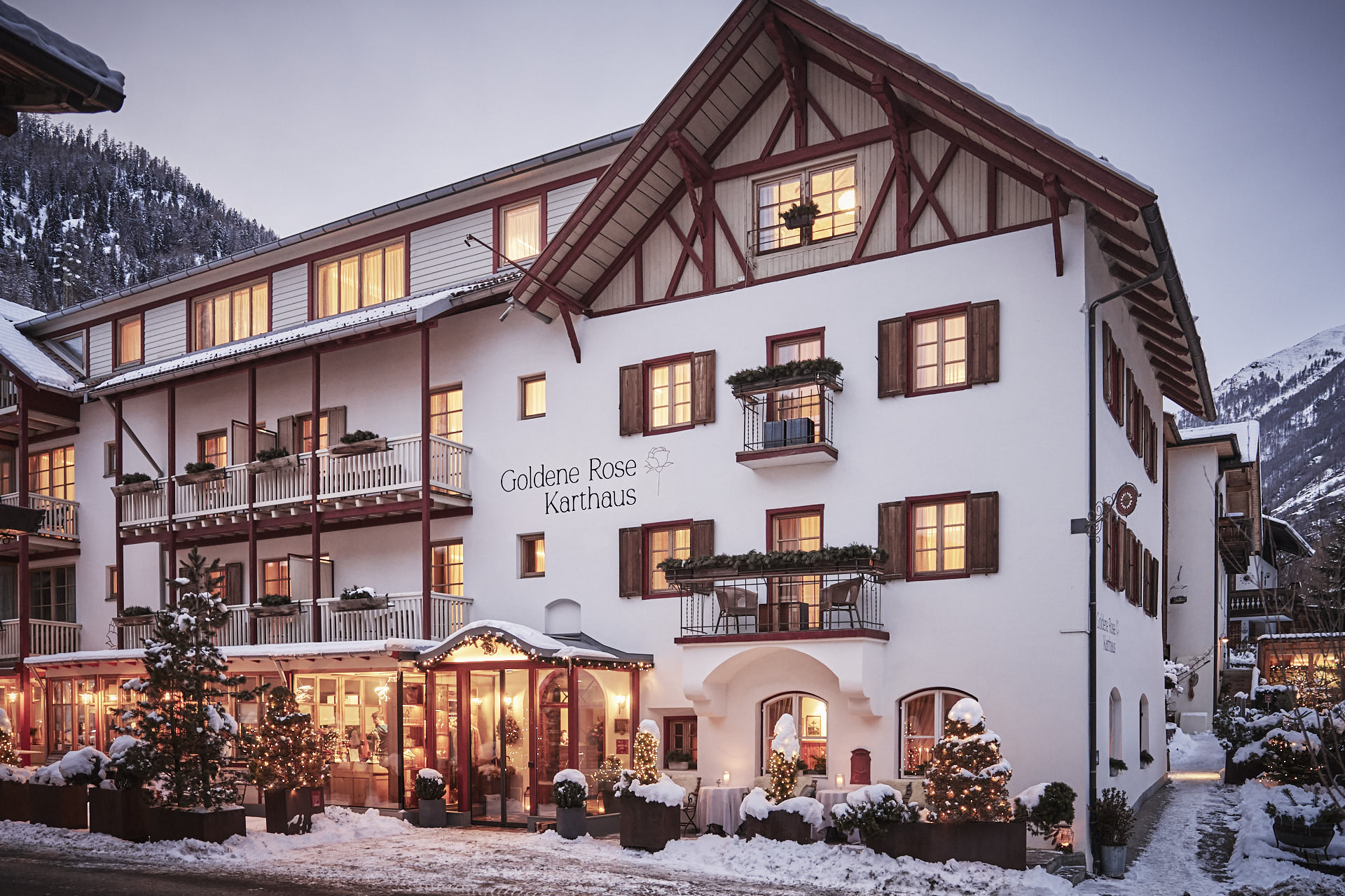 Charming hotel "Goldene Rose Karthaus" with snow-covered surroundings and festive decorations.
