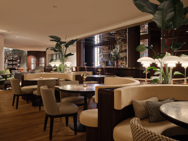Elegant interior of the Florio Bar at The Charles Hotel, featuring plush seating, stylish lighting, and greenery.