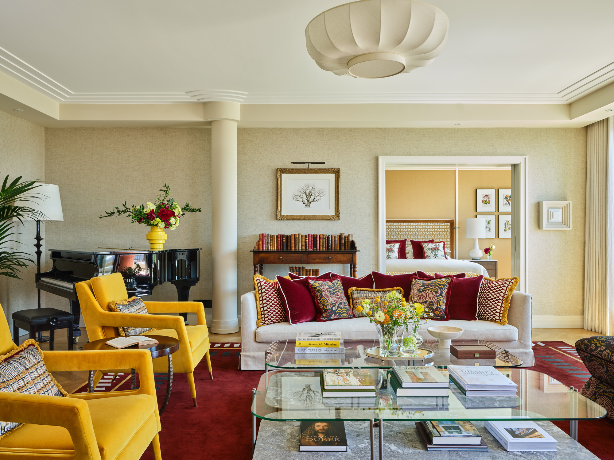 Luxurious living room in the Monforte Suite at The Charles Hotel, featuring a piano, colorful seating, and elegant decor.