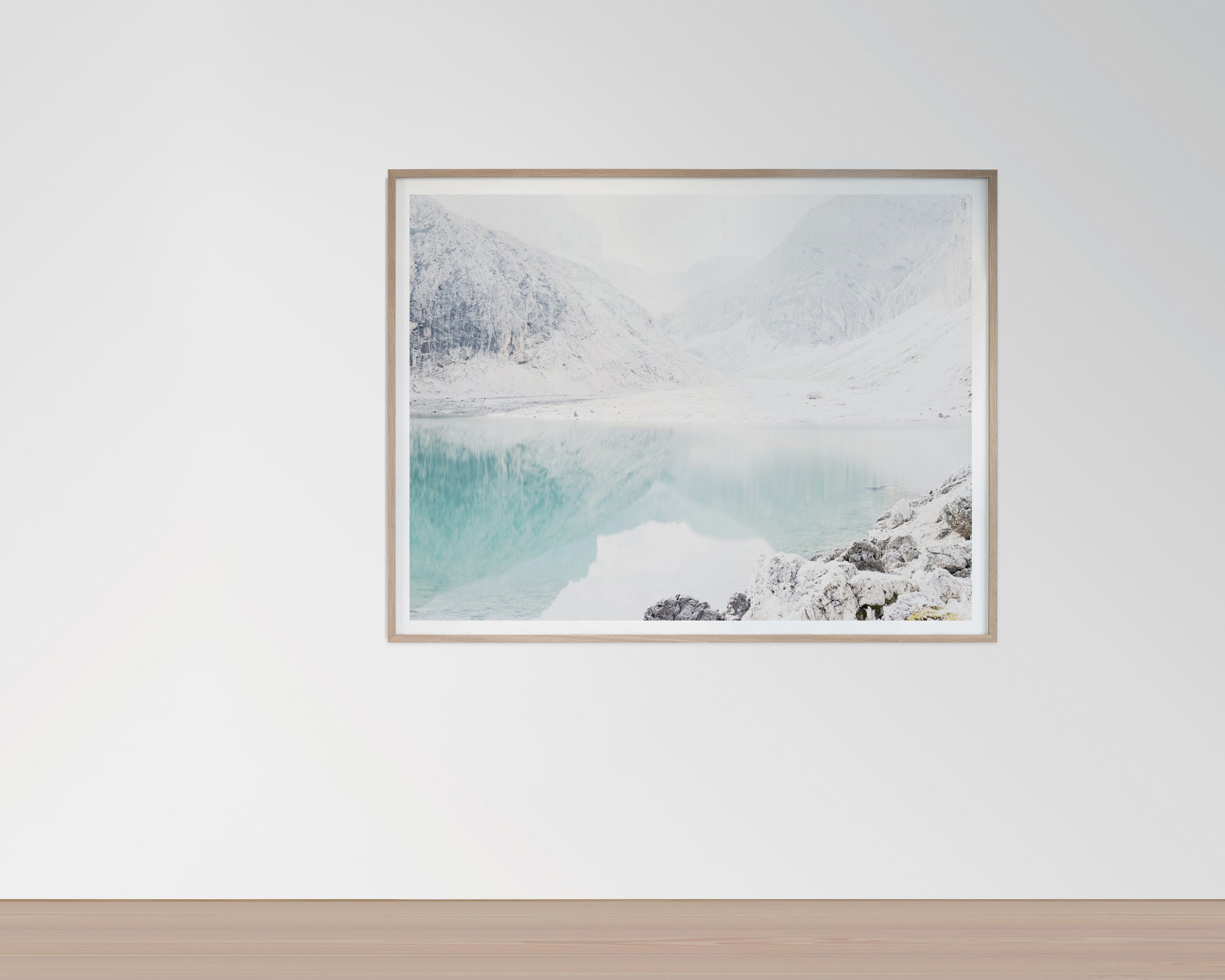 Framed artwork depicting a serene, snowy landscape with a turquoise lake and mountains in the background.