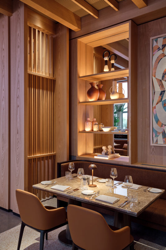 Elegant dining area in The Florentin, featuring wooden accents, artistic decor, and a well-set table.