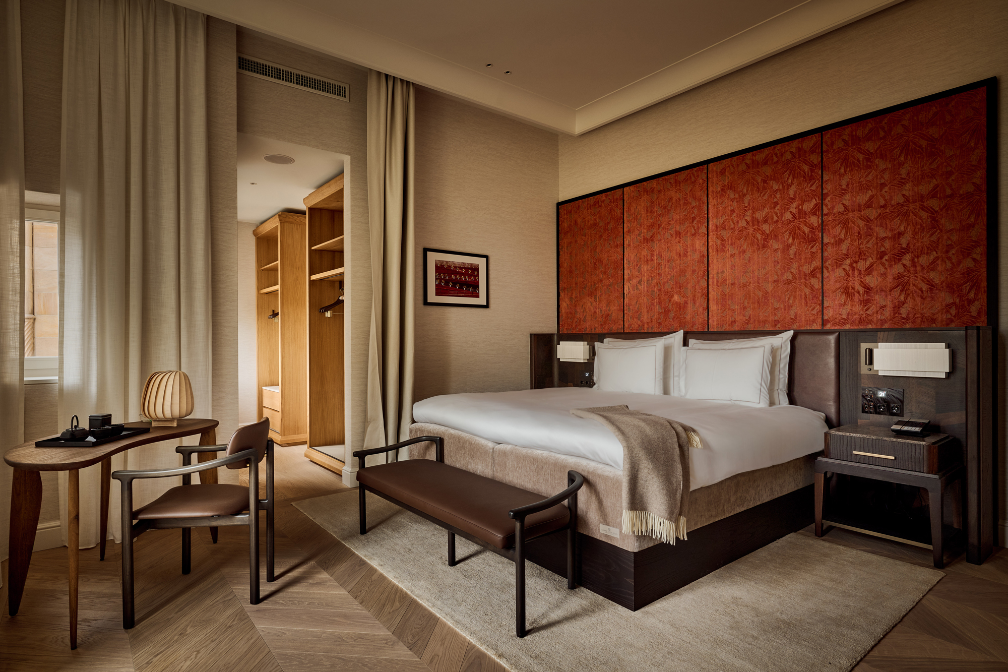 Elegant hotel room featuring a king-size bed, wooden accents, and a cozy seating area at The Florentin.