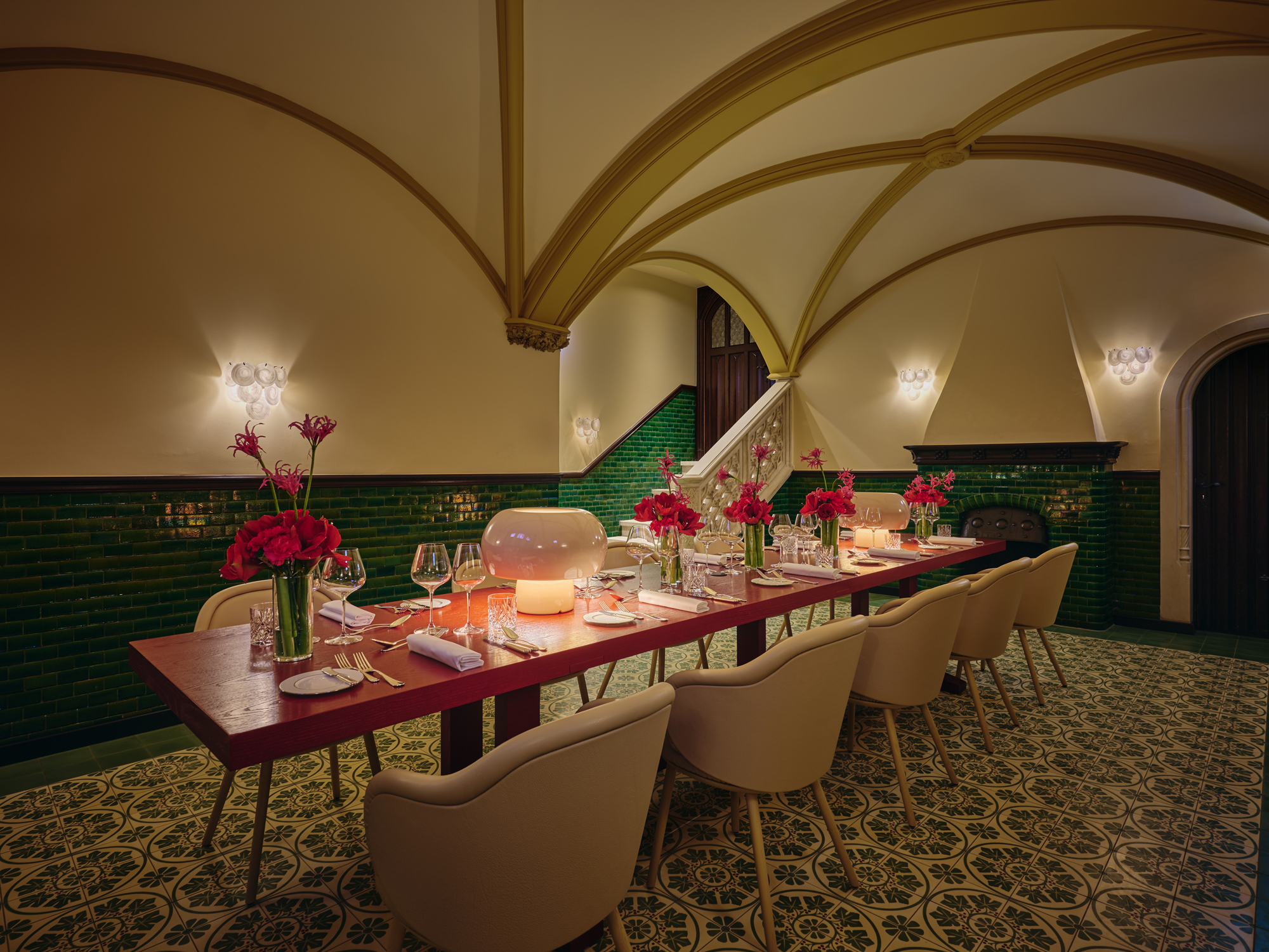 Elegant dining setup in a wine lounge featuring a long table with floral centerpieces and decorative lighting.