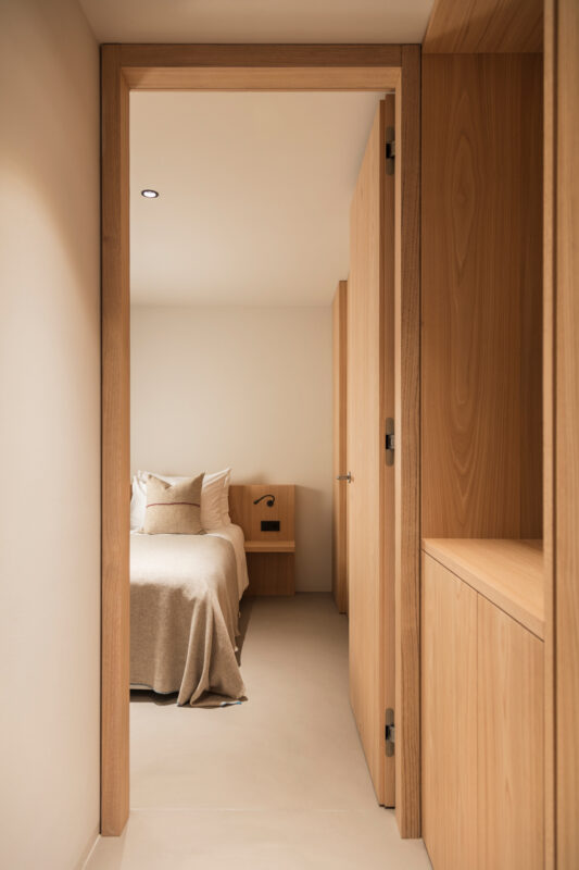 View of a cozy kids' bedroom in a family suite, featuring a bed with neutral bedding and wooden accents.