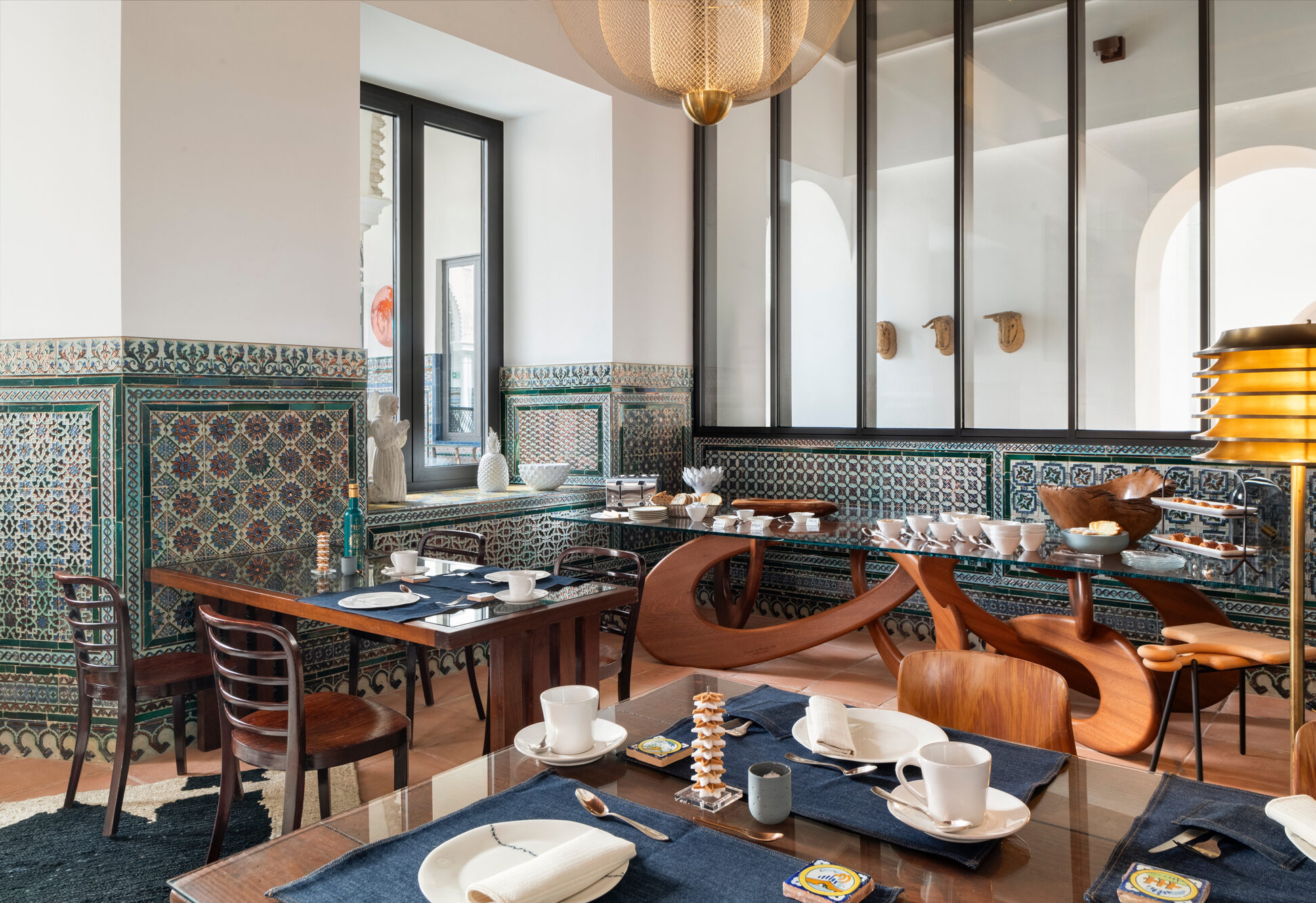 Elegant dining area in Hotel Casa Limonero, featuring intricate tile work, wooden furniture, and a stylish chandelier.