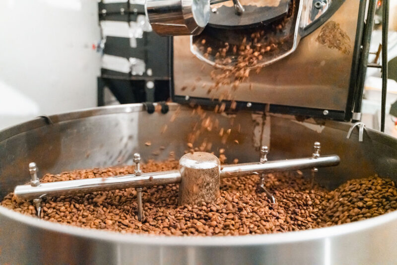 Coffee beans being roasted in a large metal roasting machine at Blaue Bohne Roastery.