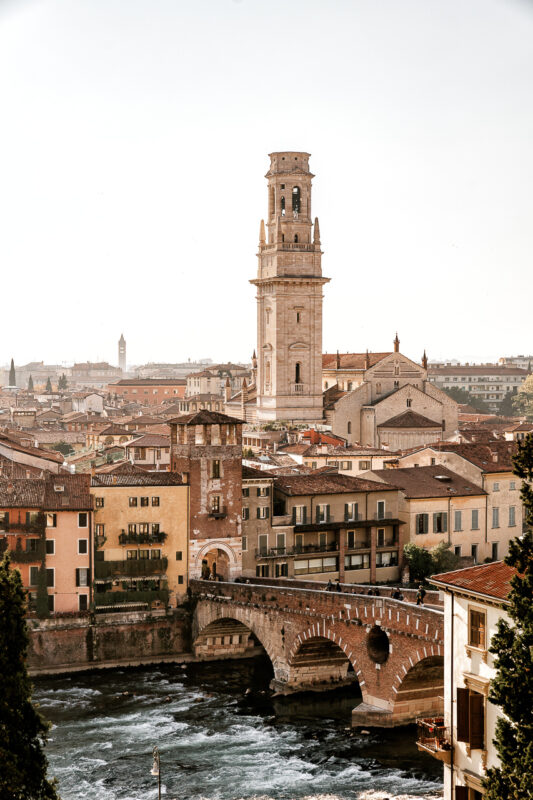 View of Verona's skyline featuring the Torre dei Lamberti, historic buildings, and the Adige River.