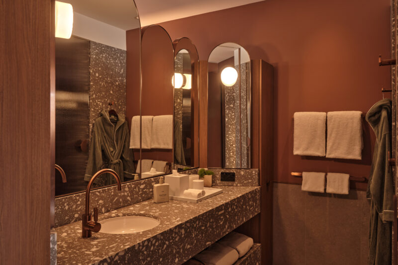 Stylish bathroom in The EVE Hotel Sydney featuring a marble sink, modern mirrors, and soft towels.