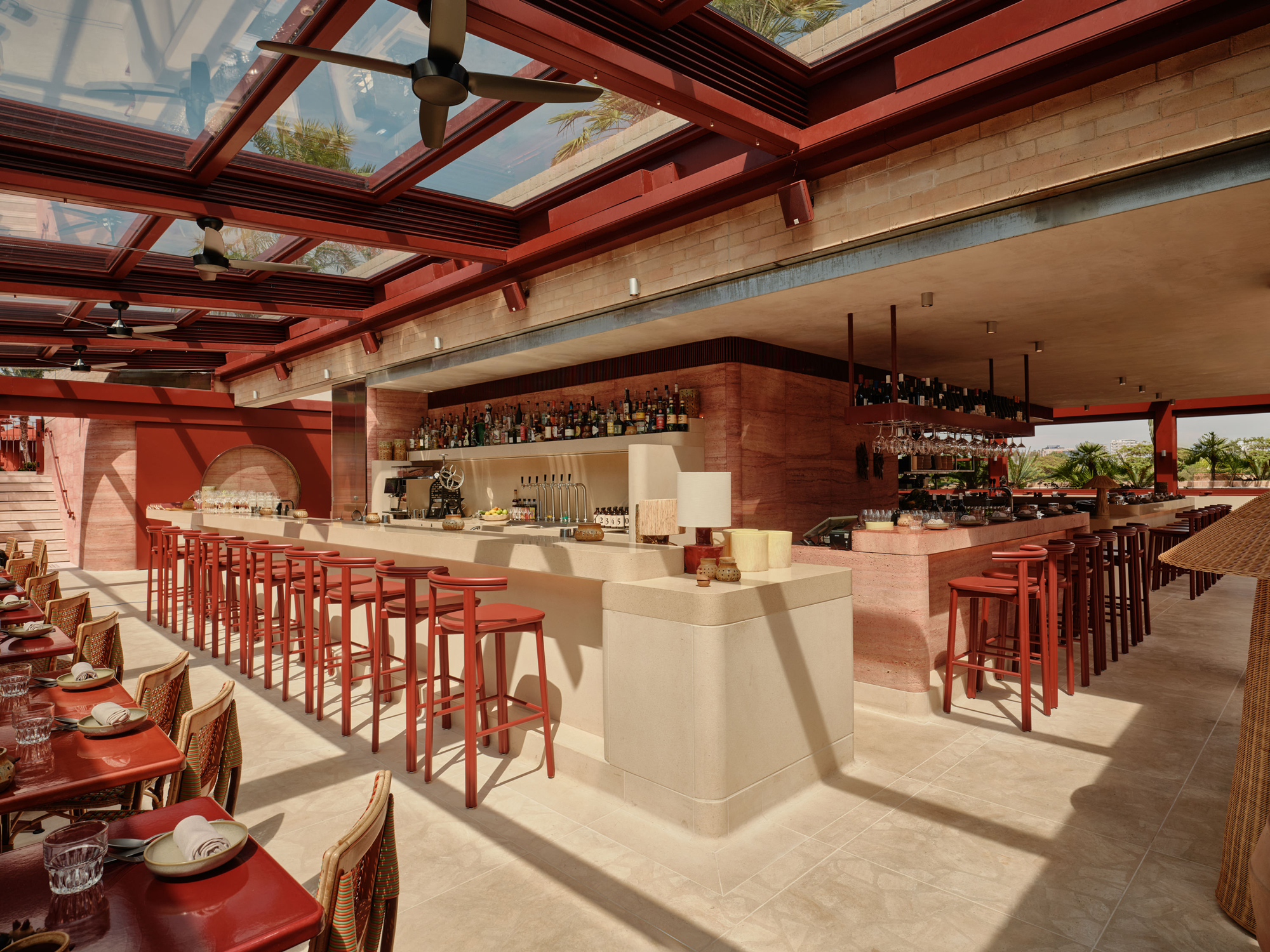 Stylish bar area in The EVE Hotel Sydney, featuring red accents, high stools, and a well-stocked counter.